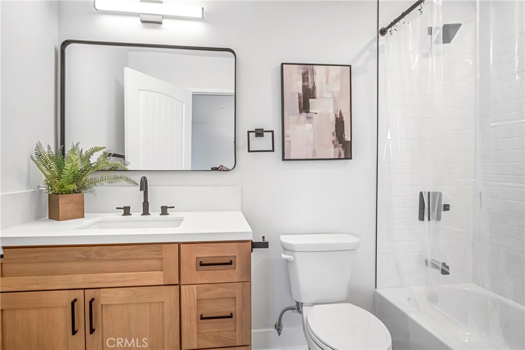10035 South Western Avenue, Unit 101 Los Angeles, CA 90047 - Photo 12 of 22 a bathroom with a sink a toilet and a mirror