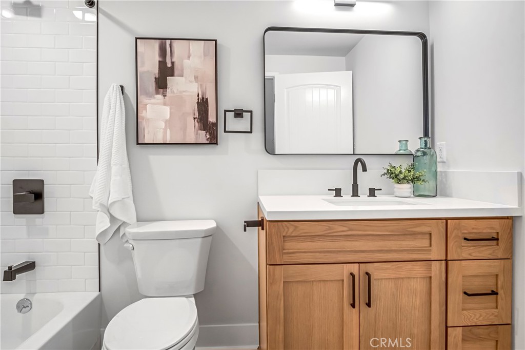 10035 South Western Avenue, Unit 101 Los Angeles, CA 90047 - Photo 6 of 22 a bathroom with a toilet sink and mirror