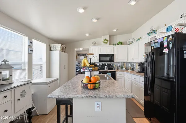 a kitchen with stainless steel appliances kitchen island granite countertop a refrigerator a stove a sink dishwasher with a dining table and chairs