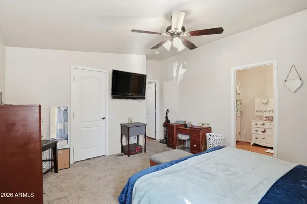 a bedroom with a bed and a flat tv screen on dresser