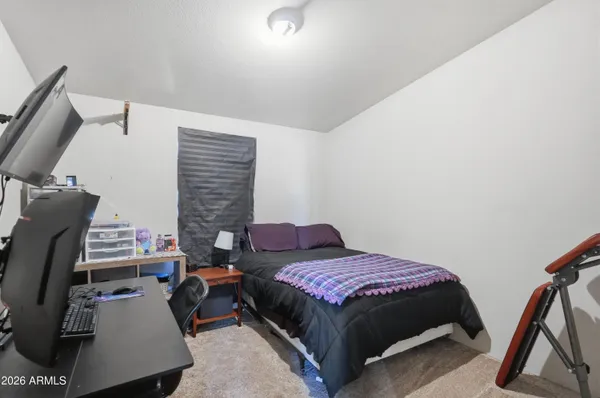 a bedroom with a bed a flat screen tv and windows