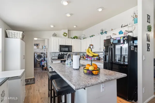 a kitchen with stainless steel appliances granite countertop a sink refrigerator and microwave