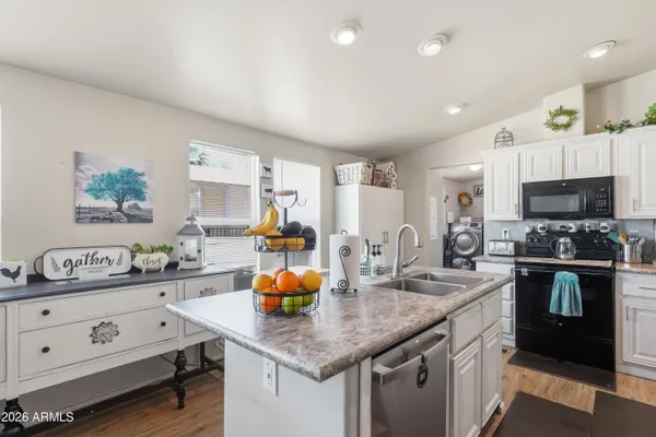 a kitchen with stainless steel appliances a sink a stove and cabinets