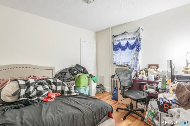 a bedroom with bed and a chair