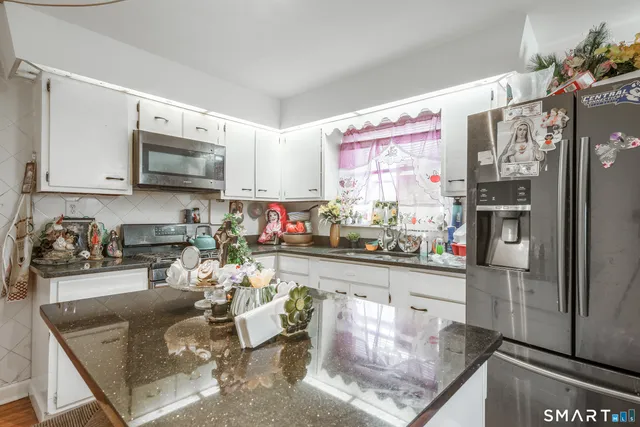 a kitchen with stainless steel appliances granite countertop a refrigerator sink and microwave