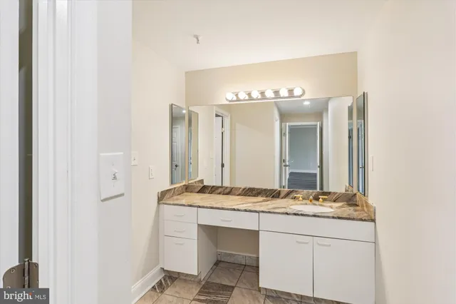 a bathroom with a granite countertop sink and a mirror