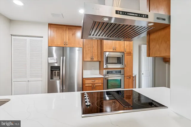 a kitchen with stainless steel appliances a refrigerator and a counter top space