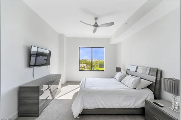 a bedroom with a bed and a flat screen tv