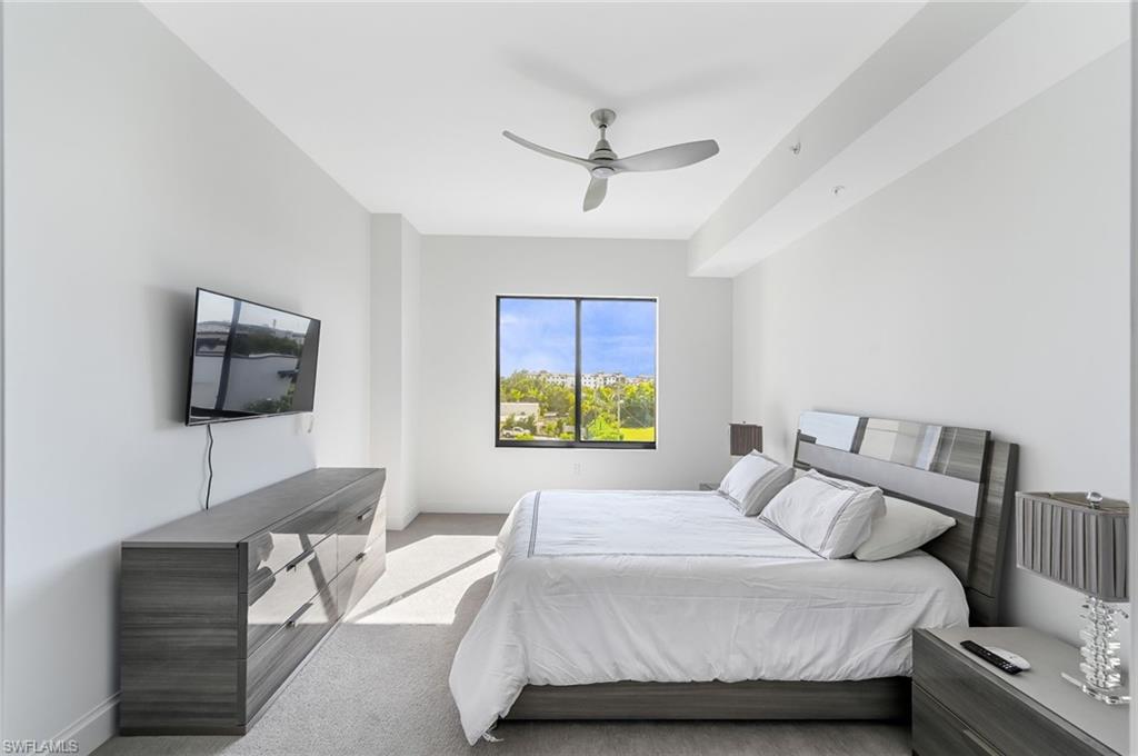 1111 Central, Unit 417S Naples, FL 34104 - Photo 12 of 25 a bedroom with a bed and a flat screen tv