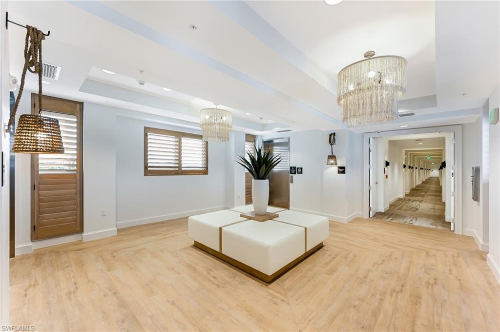 1111 Central, Unit 417S Naples, FL 34104 - Photo 17 of 25 a bedroom with a large bed and a chandelier