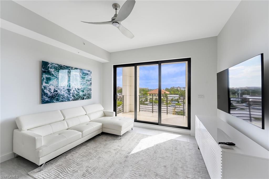 1111 Central, Unit 417S Naples, FL 34104 - Photo 4 of 25 a living room with furniture large windows and a flat screen tv