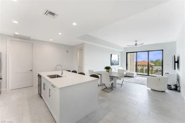 a kitchen with stainless steel appliances a sink a stove a refrigerator and cabinets