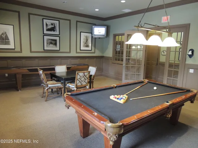 a room with furniture pool table and windows