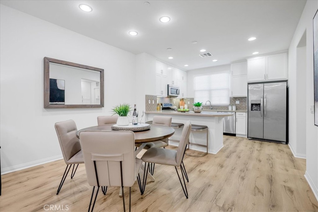 148 Capricorn Irvine, CA 92618 - Photo 10 of 66 a kitchen with stainless steel appliances kitchen island granite countertop a refrigerator and a dining table
