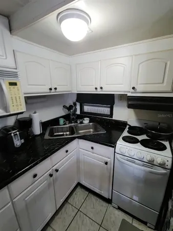 a kitchen with white cabinets and appliances