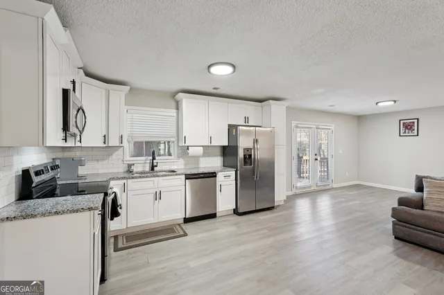 a kitchen with refrigerator and cabinets