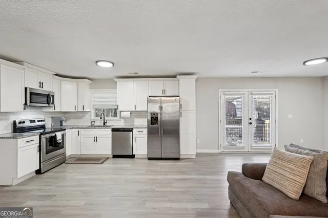 a kitchen with stainless steel appliances granite countertop a refrigerator stove top oven and sink