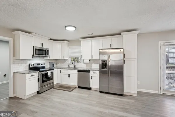 a kitchen with a refrigerator stove top oven and sink