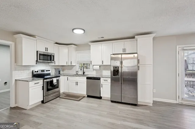 a kitchen with a refrigerator stove top oven and sink