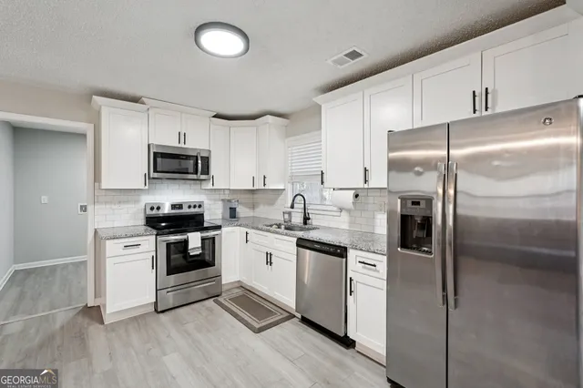a kitchen with cabinets stainless steel appliances and a counter space