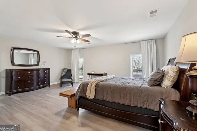 a bedroom with a bed a chandelier and a dresser