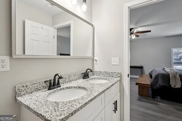 a bathroom with a granite countertop sink a mirror and vanity