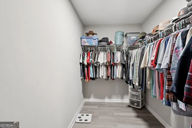 a view of walk in closet with clothes and shoes