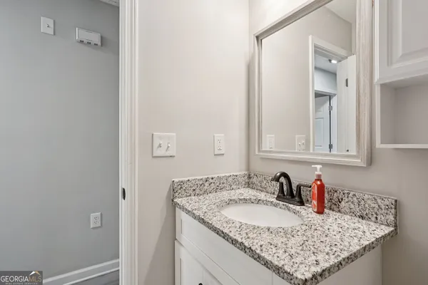 a bathroom with a granite countertop sink and a mirror