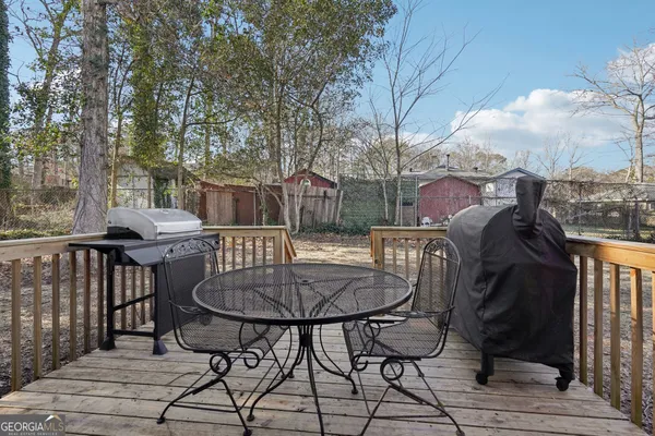 a view of house with wooden deck and furniture