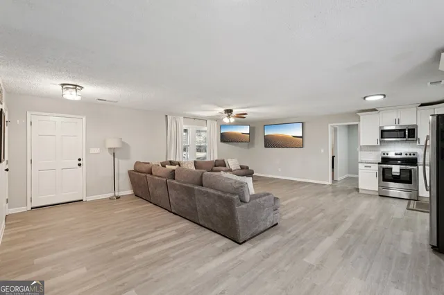 a living room with furniture and a wooden floor