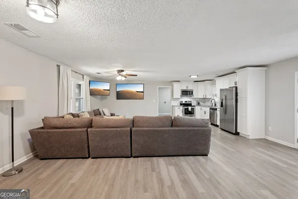 a living room with furniture and a wooden floor