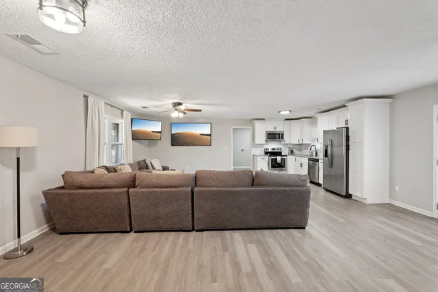 a living room with furniture and a wooden floor