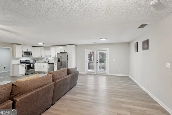 a living room with furniture and a wooden floor