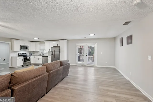 a living room with furniture and a wooden floor