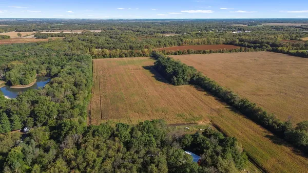 an aerial view of ocean and residential houses with outdoor space