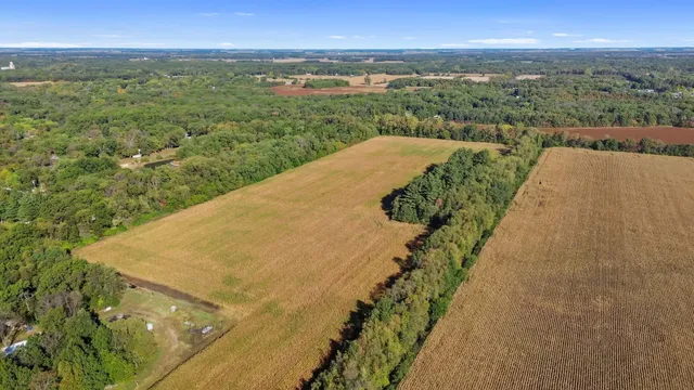 an aerial view of ocean and residential houses with outdoor space