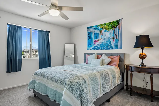 a bedroom with a bed and a painting on the wall