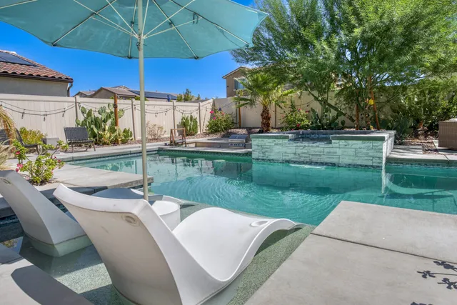 a living room with stainless steel appliances kitchen island granite countertop a dining table chairs and a refrigerator