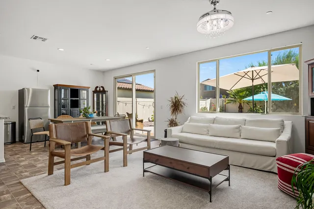 a living room with furniture a large window and a table