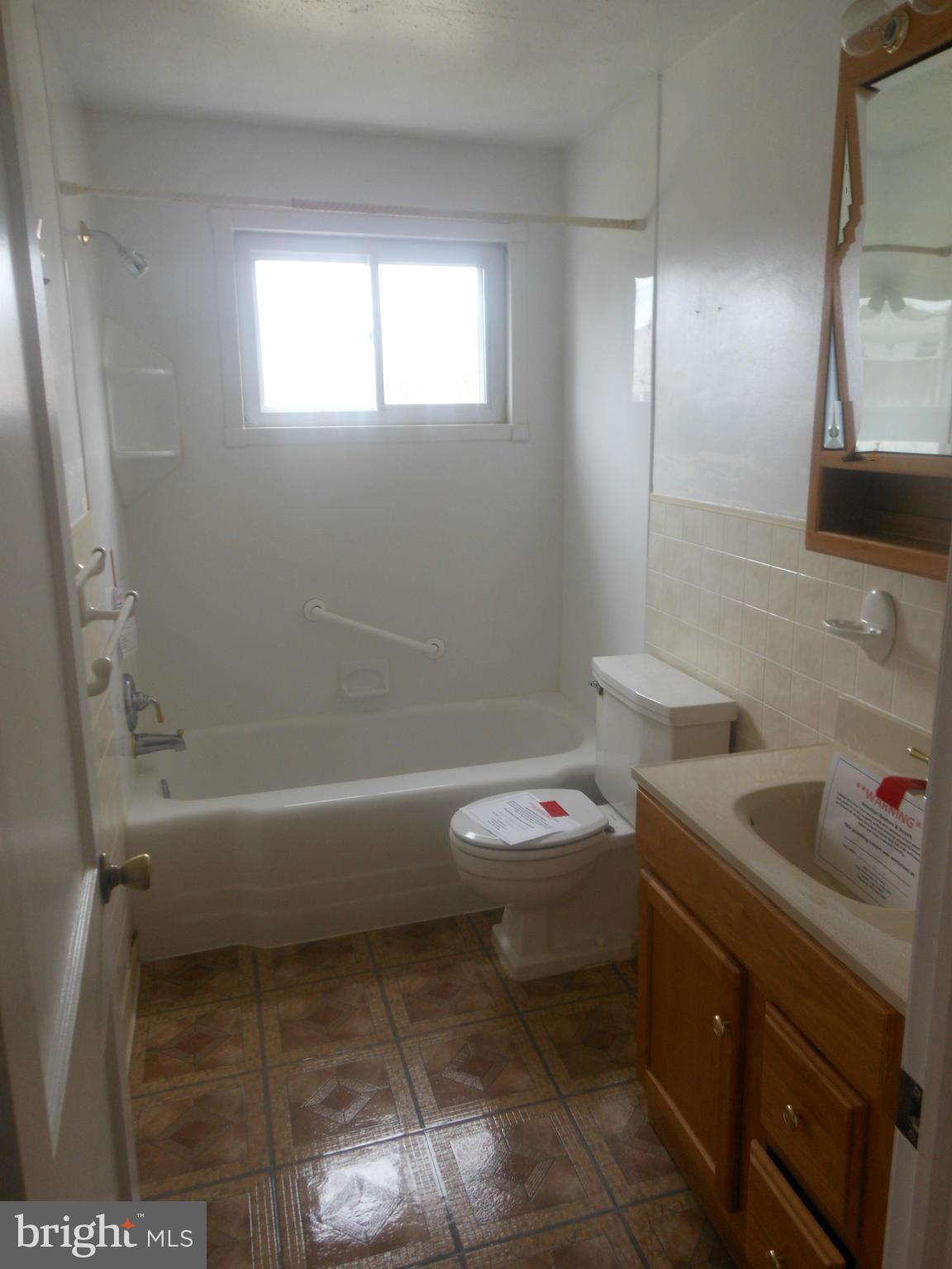 1413 Barrett Road Baltimore, MD 21207 - Photo 11 of 13 a bathroom with a sink a toilet and a bathtub