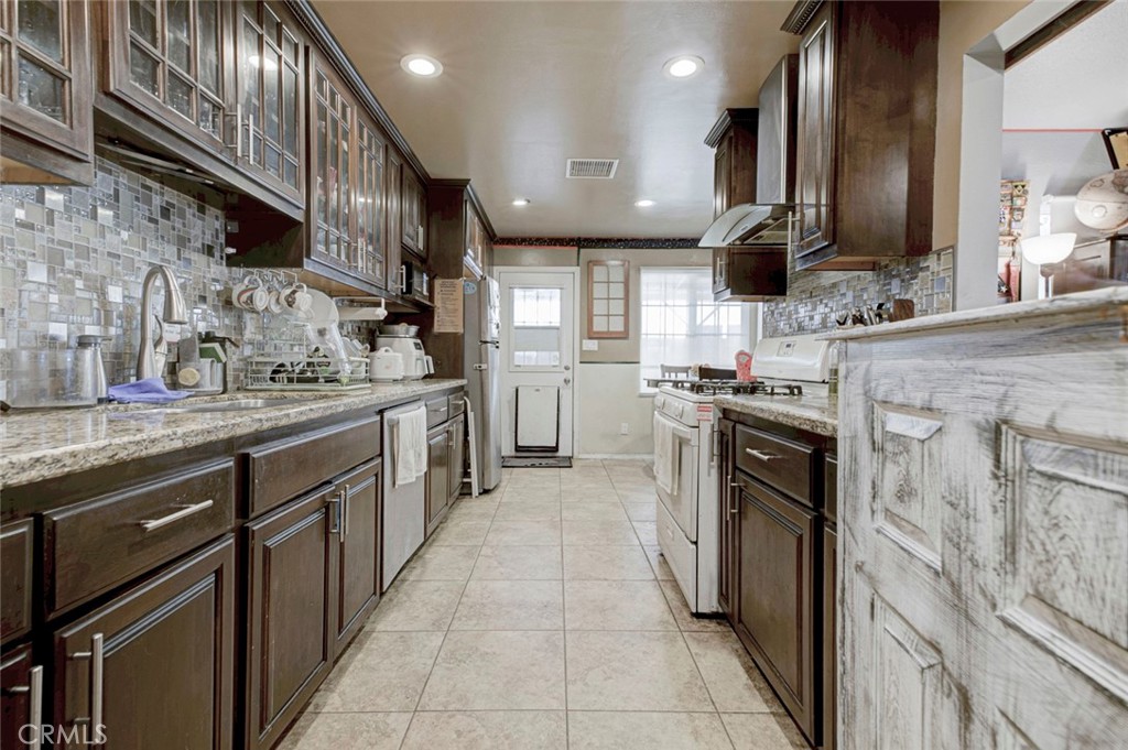 1029 East Galatea Street Azusa, CA 91702 - Photo 19 of 36 a kitchen with stainless steel appliances granite countertop a sink a stove and a refrigerator