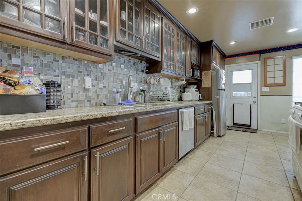 1029 East Galatea Street Azusa, CA 91702 - Photo 20 of 36 a kitchen with stainless steel appliances granite countertop a sink and cabinets