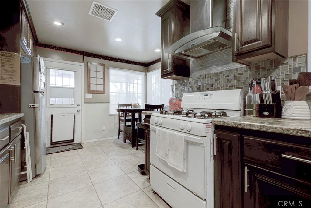 1029 East Galatea Street Azusa, CA 91702 - Photo 21 of 36 a kitchen with stainless steel appliances granite countertop a sink stove and refrigerator