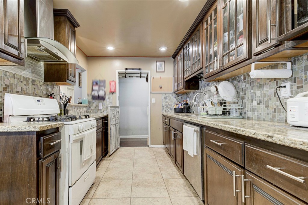 1029 East Galatea Street Azusa, CA 91702 - Photo 23 of 36 a kitchen with stainless steel appliances granite countertop a sink a stove a refrigerator and a refrigerator