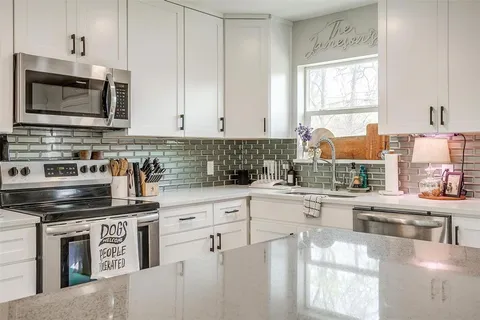 a kitchen with stainless steel appliances a stove a sink and a microwave