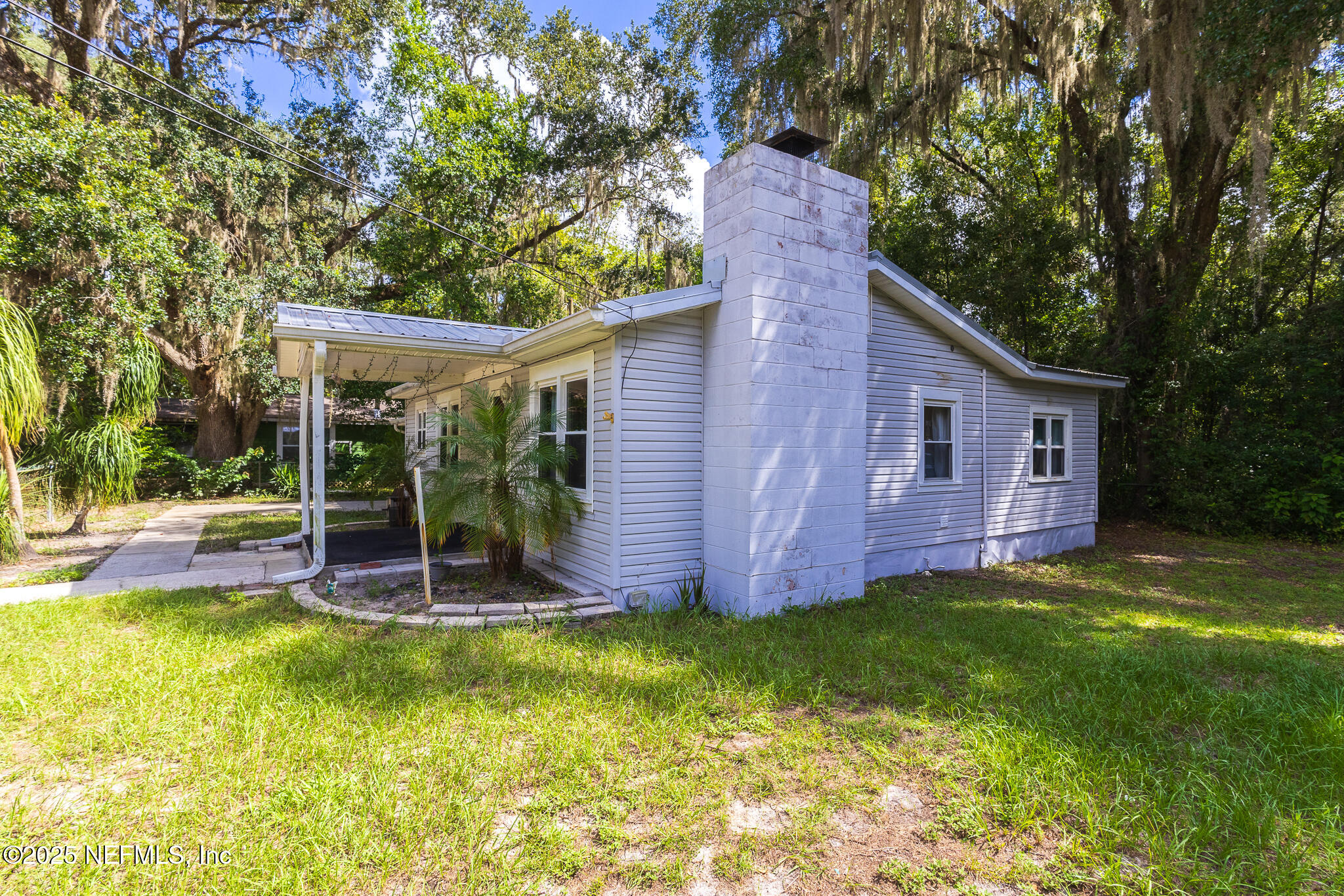 128 Devils Elbow Palatka, FL 32177 - Photo 19 of 38 a view of a backyard with table and chairs potted plants and large tree