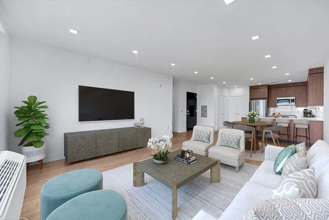 a living room with furniture a flat screen tv and a large window