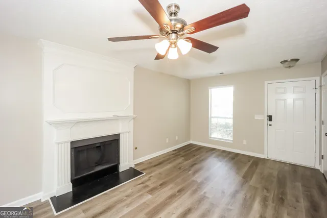 an empty room with windows and fireplace
