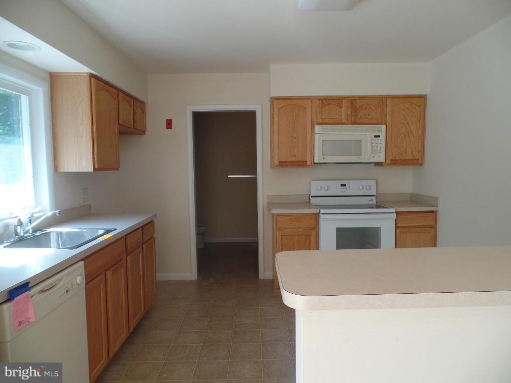 212 Ewingtown Road Church Hill, MD 21623 - Photo 2 of 10 a kitchen with stainless steel appliances granite countertop a sink stove and refrigerator