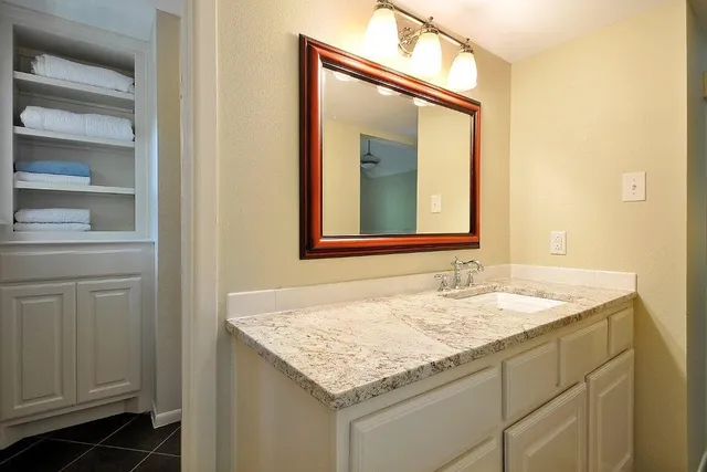 a bathroom with a granite countertop sink and a mirror